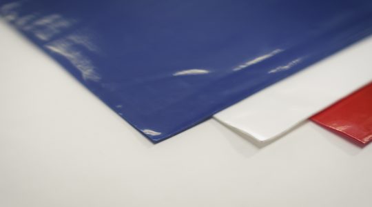 A picture of mats lying one over another - a blue mat, a red mat and a white mat.